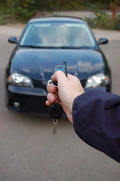 Car safeguard. Man hand with alarm key ring