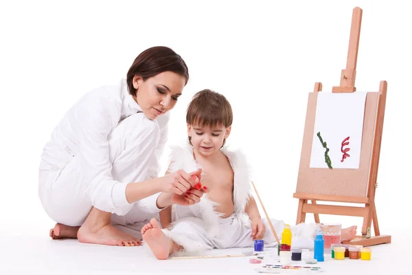 Happy mom and son learning to paint near easel