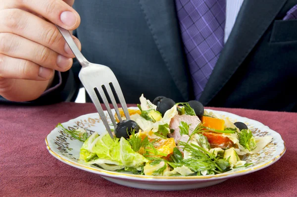 Man eating salad. Hand with fork closeup