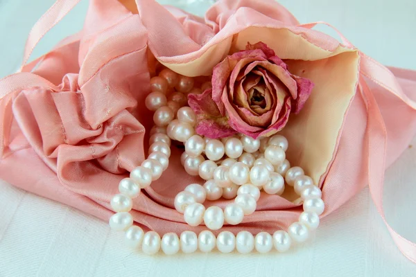 White pearls in a pink bag