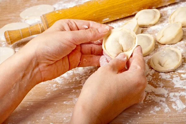 Womens hands are preparing pelmen. by aelena - Stock Photo