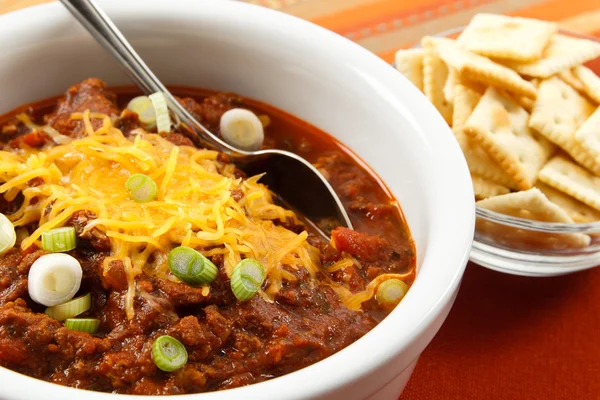 Hearty chili with cheese and scallions