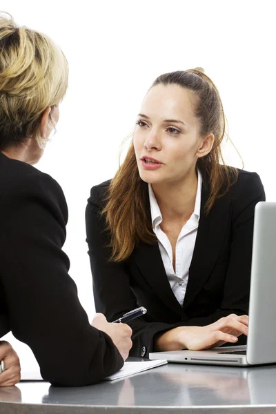 Two women during a business meeting with laptop on white background studio