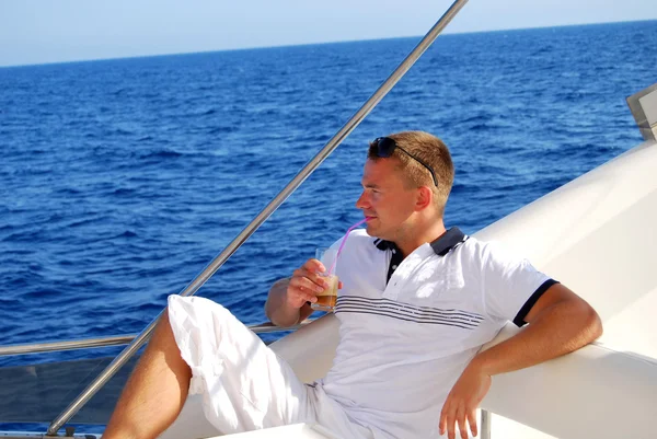 Sailor relaxing on boat drinking cold coffee