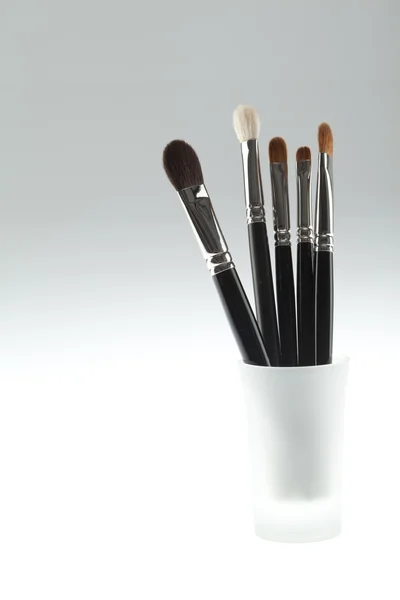 A set of 5 make-up brushes set in a small glass — Stock Photo #4372268