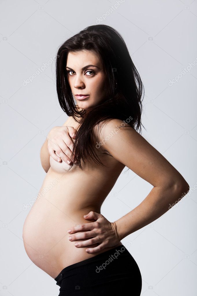 Young pregnant woman from side covering her breasts big young breasts