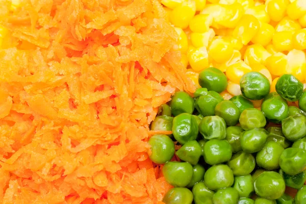 Boiled diced vegetables background with carrot, corn and peas
