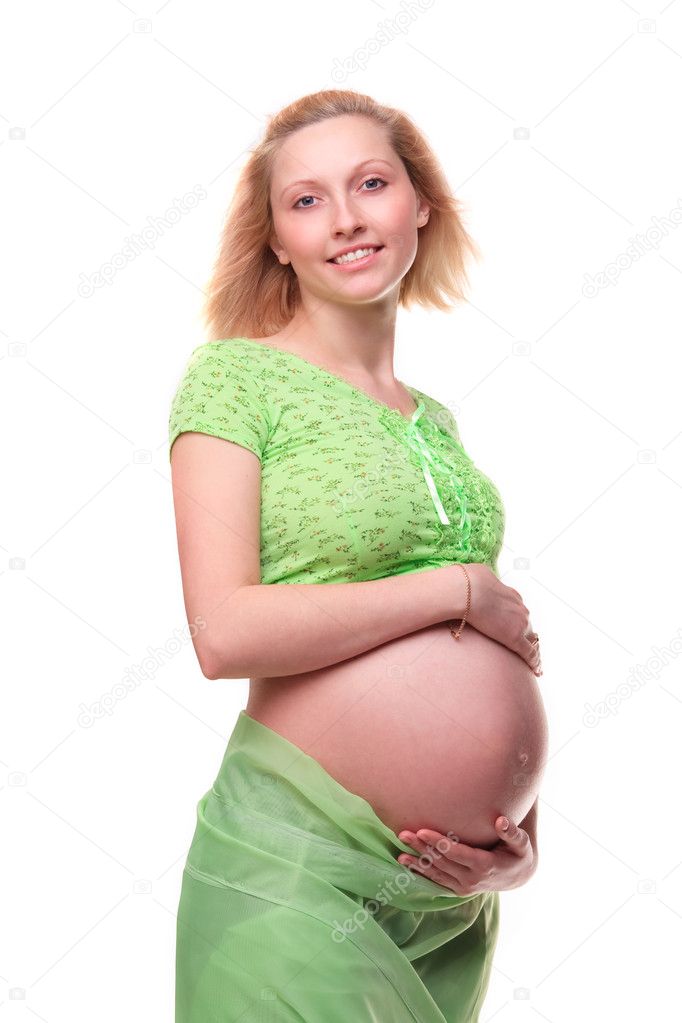 Beautiful young pregnant blonde woman with green transparent cloth in studio