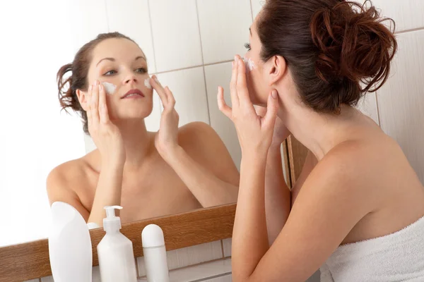 Body care series - Beautiful young woman applying cream