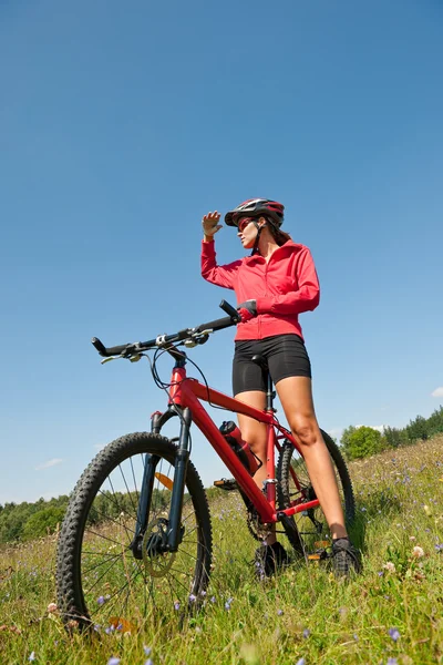 Young woman with mountain bike in spring nature