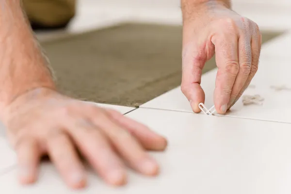 Home improvement - handyman placing tile spacer