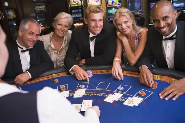 Group of friends playing blackjack in casino