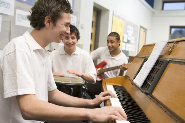 Schoolboys playing musical instruments in music class