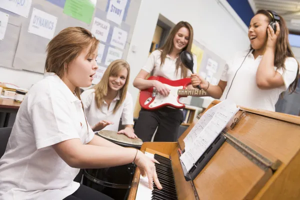 Schoolgirls playing musical instruments in music class