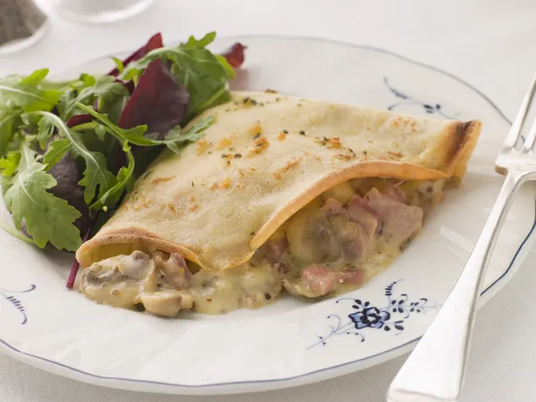 savoury pancake filled with ham cheese and mushrooms with dresse