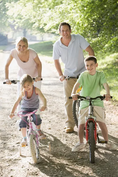 Family on bikes on path smiling