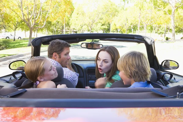 Family in convertible car arguing