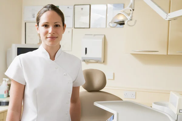 Dental assistant in exam room smiling