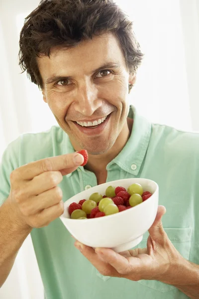 Mitte erwachsenen mann essen frisches obst – Stockdatei