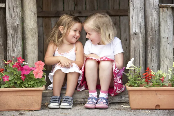 Two Young Girls Playing in Wooden House by Monkey Business Stock Photo