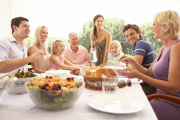 A family, with parents, children and grandparents, enjoy a picni