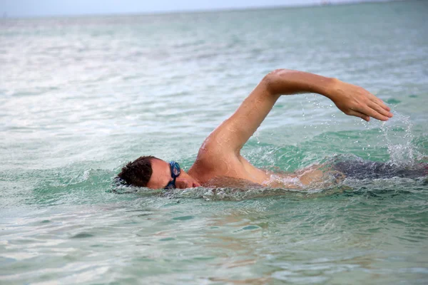 Young man swiming in oceans water