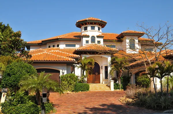 Spanish style home with tower, multiple roofs