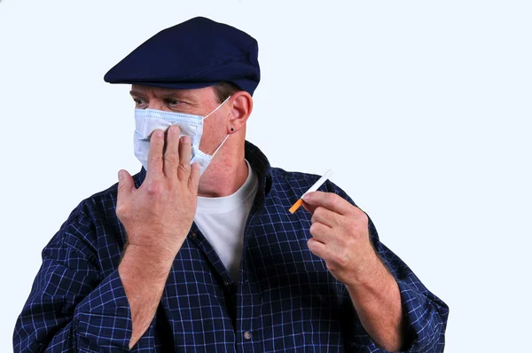Man with breathing mask turning away from cigarette
