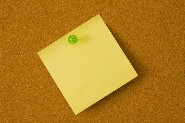 Yellow post it with green push pin