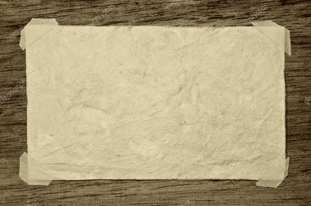 Old grunge paper on the dark wood background