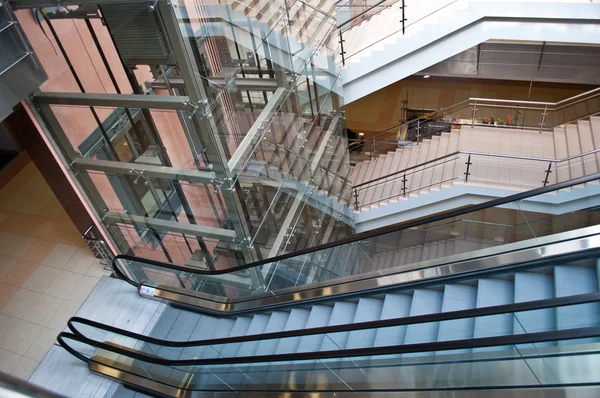 Glass elevator shafts, escalators and stairs in a modern office building
