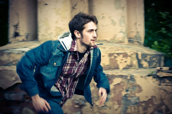 Young man wearing jeans clothes running