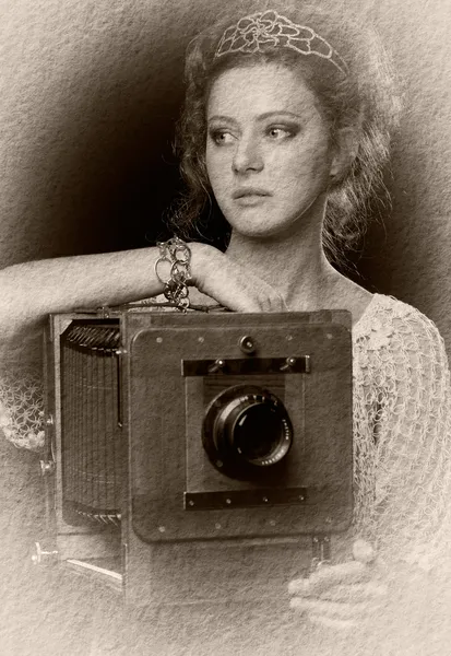 Young woman near the old camera