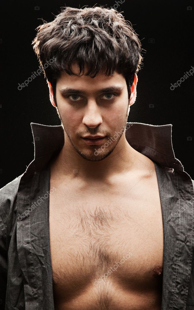 Handsome man with naked breast against black background