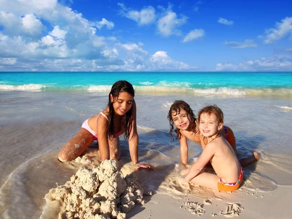 Three little girls mixed ethnicity playing beach