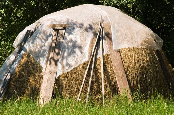 stock image A large stack of hay covered with cellulosic packing material