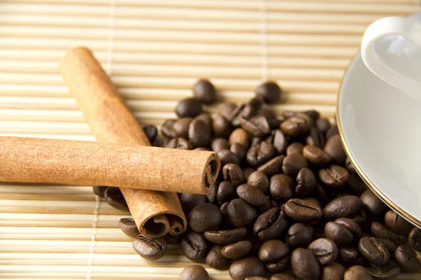Kávová zrna a skořicí s uzávěrem na bambusové rohože — Stock fotografie