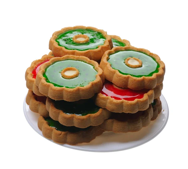 Biscoitos com geleia vermelha e verde na placa branca, isolados — Fotografia de Stock