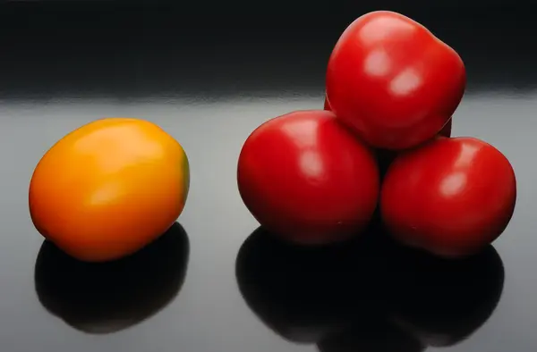 Flerfargede tomater på svarte bakgrunner – stockfoto