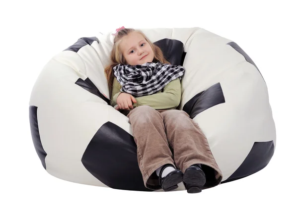 白い背景に分離したサッカー ボールの形で 膨脹可能な椅子に座って長いブロンドの髪の少女 — ストック写真