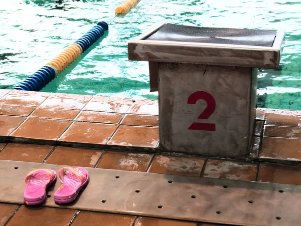 Zapatillas de playa al lado de la piscina — Foto de Stock