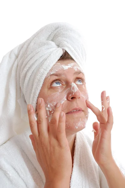 Kvinna sätta grädde på hennes ansikte — Stockfoto