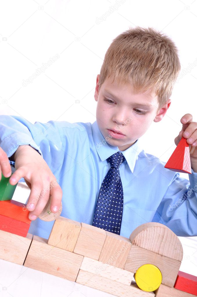 Schoolboy playing with bricks