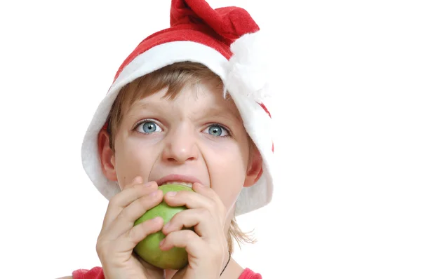 Рождественский мальчик кусает яблоко — стоковое фото