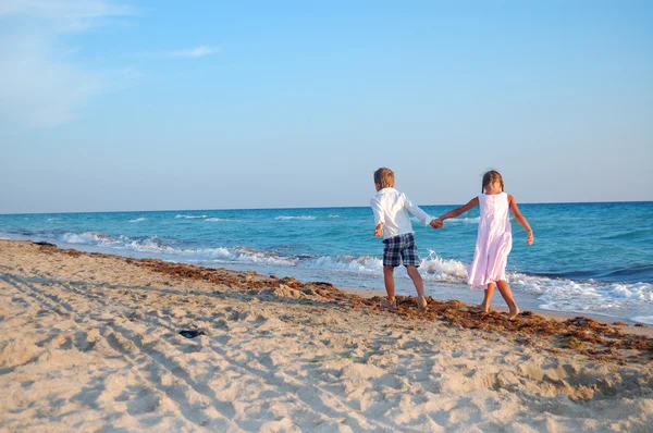 Kinderen lopen langs het strand samen — Stockfoto