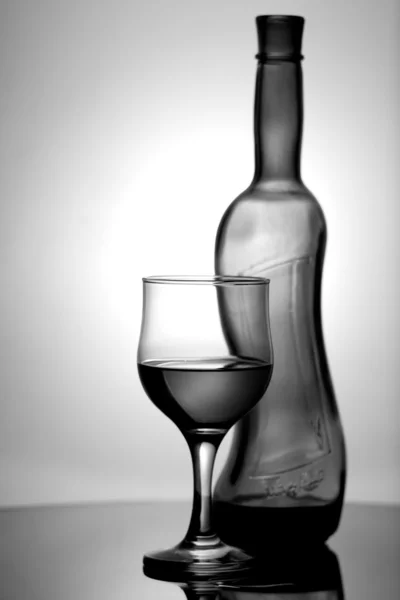 Botella de vino y botella en el escritorio . — Foto de Stock