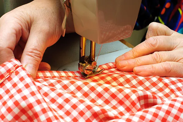 拼接牛仔布布带一台缝纫机的手 — 图库照片