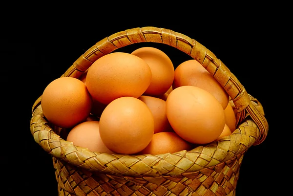 Eggs in a basket on a black background — Stock Photo, Image