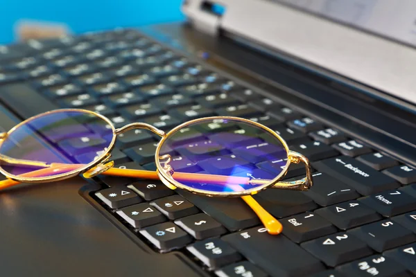 Gyllene glasögon på laptop — Stockfoto