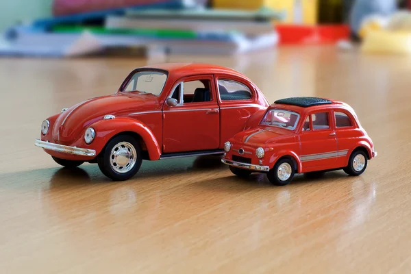 桌上的两个红色玩具车。 — 图库照片